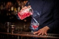 Barman pouring fresh and sweet pink summer cocktail into the glass Royalty Free Stock Photo