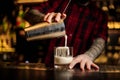 Barman pouring fresh thick creamy alcoholic drink into a glass Royalty Free Stock Photo