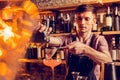 Barman pouring juice thorough sieve while making cocktail