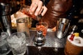 Barman is pouring out of a shaker into a crystal glass an alcoholic cocktail Royalty Free Stock Photo