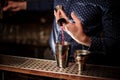 Barman pouring a portion of pink alcohol drink into the shaker