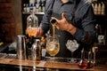 Barman pouring a portion of syrup into the large cocktail glass Royalty Free Stock Photo