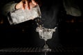 Barman pouring a transparent drink with ice cubes Royalty Free Stock Photo