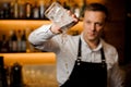 Barman pouring water from a glass with ice cubes Royalty Free Stock Photo