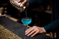 Barman pours an alcohol cocktail Blue Lagoon into the glass Royalty Free Stock Photo