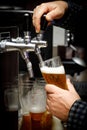 Barman pours beer into a glass