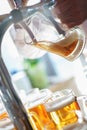 Barman pours a dark foamy beer into a large mug during the Oktoberfest party. Royalty Free Stock Photo