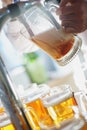 Barman pours a dark foamy beer into a large mug during the Oktoberfest party. Royalty Free Stock Photo