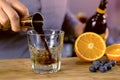 Barman pours kahlua from jigger to rocks glass with tequila preparing alcohol cocktail. Hands close-up. Royalty Free Stock Photo