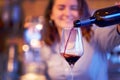 Barman pours red wine