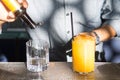 Barman preparing a yellow drink with vodka