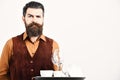 Barman with proud face serves tea or alcohol drink. Waiter with white tea cup, pot and glasses on tray. Royalty Free Stock Photo