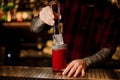 Barman putting big ice cube into a tomato bloody mary cocktail Royalty Free Stock Photo