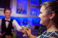 Barman serving cocktail to woman