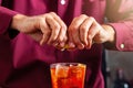 Barman squeezes the lemon peel into the cocktail