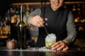 Barman stiring a fresh delicious cocktail with lime Royalty Free Stock Photo