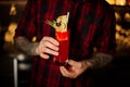 Barman holding a glass of red sweet juicy drink in a cocktail glass with fruit Royalty Free Stock Photo