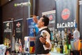 Barman throwing alcohol bottle in the air making cocktail