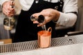 Barman in white shirt pouring a portion of alcoholic drink into a cup Royalty Free Stock Photo