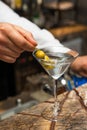 Barman at work, preparing cocktails. Preparing martini with olives.