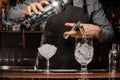 Barmans hands pouring alcoholic drink into a glass using a jigger to prepare a cocktail Royalty Free Stock Photo
