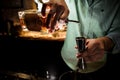 Barmans hands pouring a syrup for making a cocktail