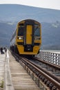 BARMOUTH, GWYNEDD UK - APRIL 09 : Train travelling over the viaduct in Barmouth, Gwynedd on April 09, 2023. Unidentified people