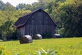 Barn captured in a countryside with covered hays in front of it