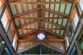 Barn ceiling with crossbeams and corrugated metal roof, circular window