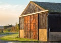 Barn on farmland with metal red and rusty doors. Royalty Free Stock Photo