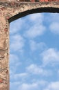 Barn gate door arch and sky, stone wall closeup, vertical bright white summer clouds cloudscape copy space background, plastered Royalty Free Stock Photo