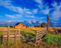 A barn sits in a meadow in front of the majestic Grand Teton Range in Wyoming Royalty Free Stock Photo