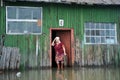 An unknown elderly woman in her home during a flood. The Ob river, which came out of the banks, flooded the outskirts of the city.