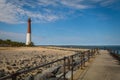 Barnegat Lighthouse on Long Beach Island, NJ, on a sunny spring day with blue sky dotted with clouds