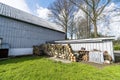 Barnyard with green grass and a woodstack