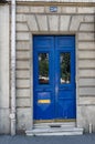 Double door panels with door windows with reflective glass protected by ornate lattice. Blue painted antique door Royalty Free Stock Photo