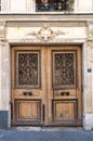 Aged double door entrance of old building in Paris France. Vintage wooden doorway and ornamental stucco fretwork wall. Royalty Free Stock Photo