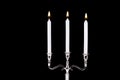 Baroque silver candlestick with white paraffin candles burning isolated on black background Royalty Free Stock Photo