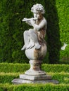 Baroque statue in castle park, little boy playing the flute Royalty Free Stock Photo