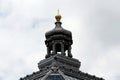 Baroque style dome with golden tip on top of old building with glass and metal roof tiles surrounded with various decorative Royalty Free Stock Photo