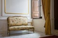 Baroque style sofa near window. Classic interior with marble floor and white,gold walls. Castle hall. Romantic interior style.