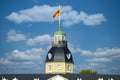 Baroque tower of Karlsruhe Palace with peope on viewpoint in front of blue sky