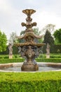 Baroque water fountain in green chateu garden Royalty Free Stock Photo