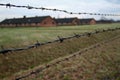 Barracks behind barbed wire at Auschwitz - Birkenau concentration camp Royalty Free Stock Photo