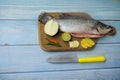 Barramundi or asian seabass fish with knife, chilies, onion , lemongrass, ginger,garlic,and key lime over the wooden cutting board