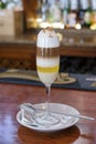 Barraquito, an exquisite coffee based alcoholic beverage served in a tall flute glass, tasty layered drink with milk and espresso