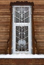 Barred window in brown old wooden house Royalty Free Stock Photo