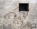 Barred window in eroded wall