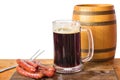 Barrel glass of beer and grilled sausages.