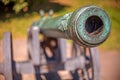 Barrel of old vintage copper cannon on wheels and carriages with a blurred background